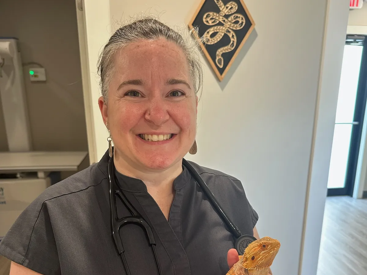 Dr. Angela Melton holding a bearded dragon at Happy Paws & Claws